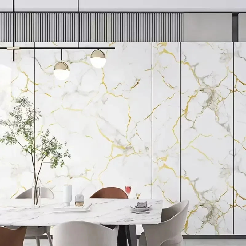 Salle à manger moderne avec une table et des chaises en marbre blanc et des décals de veinage or.
