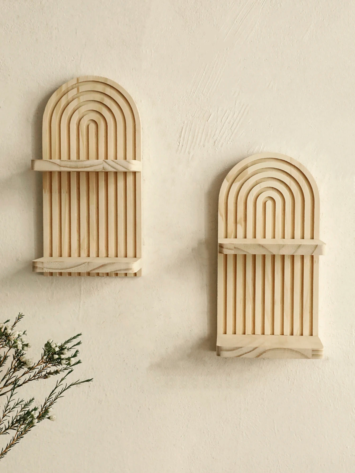 Two wooden wall shelves with arched, ribbed designs mounted on a light-colored wall.