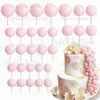 A set of pink and white foam cake toppers, including round balls and floral accents.