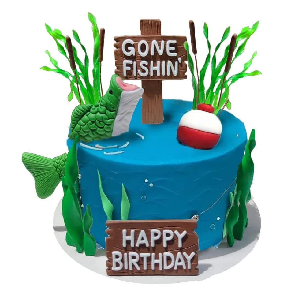 A blue fishing theme cake decorated with wooden signs and green foliage, featuring a white and red spherical topper.