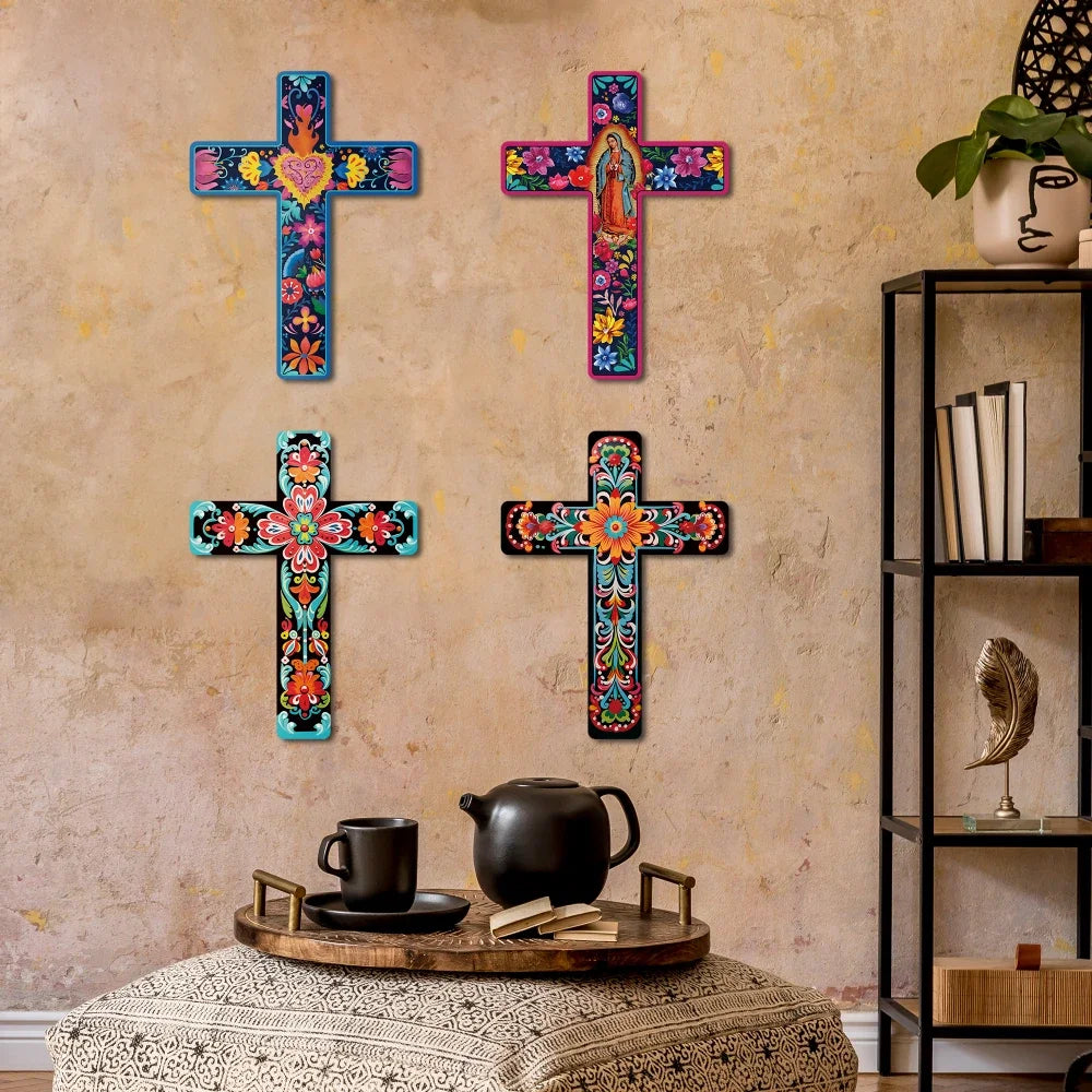 Four colorful wooden crosses in various sizes and designs displayed on a textured wall.
