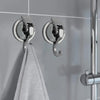 Silver suction cup hooks mounted on a shower rod, used for hanging towels.