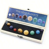 An open wooden box displaying nine natural crystal gemstone spheres representing the nine planets.