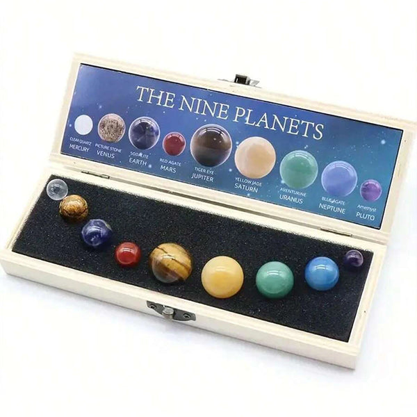 An open wooden box displaying nine natural crystal gemstone spheres representing the nine planets.