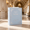 A light blue photo album with gold foil detailing sits on a polished marble floor in a grand, ornate hall.