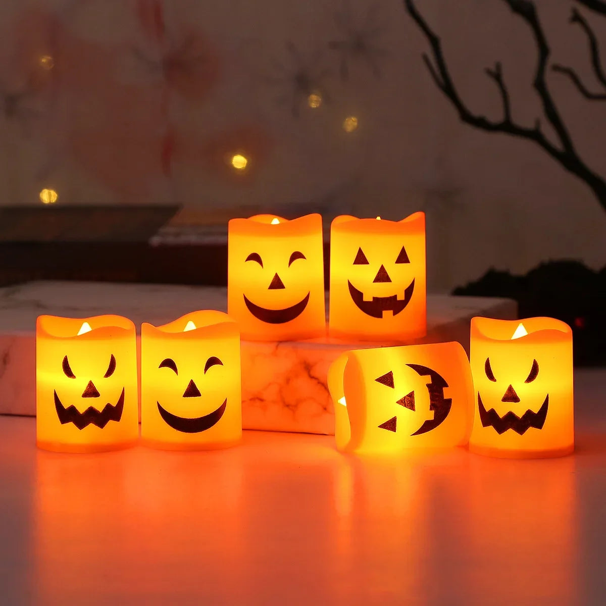 A set of six glowing orange Halloween LED candle lights arranged on a smooth surface.