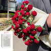 A handmade rose bouquet blanket gift featuring vibrant red roses and green foliage wrapped in a cream-colored knitted blanket