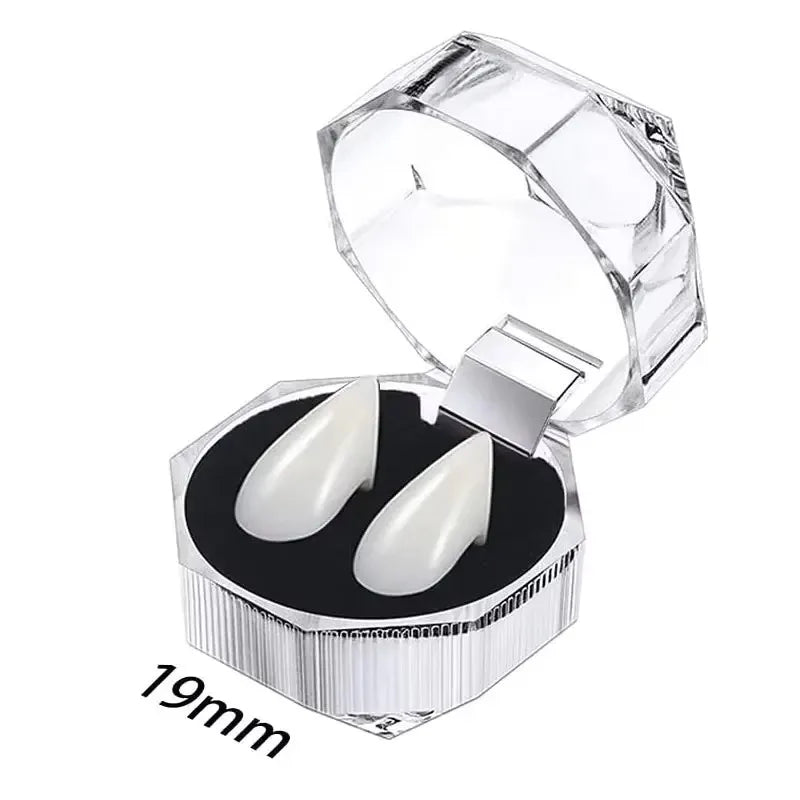 Clear plastic case with a lid open displaying realistic white vampire fangs