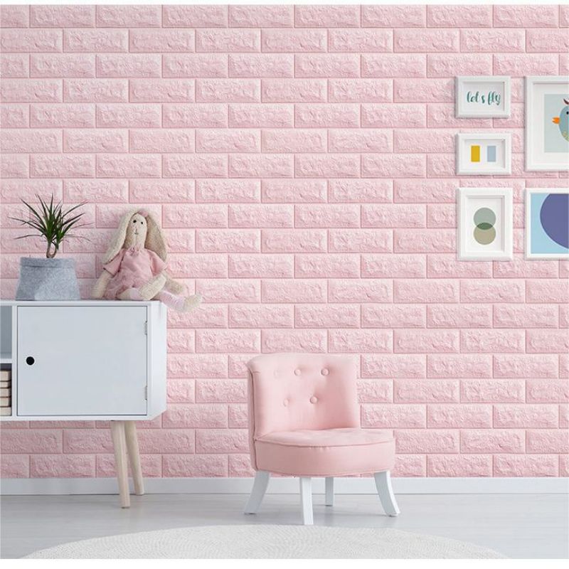 Pink textured brick wall panels with white furniture and a pink chair in a bright room.