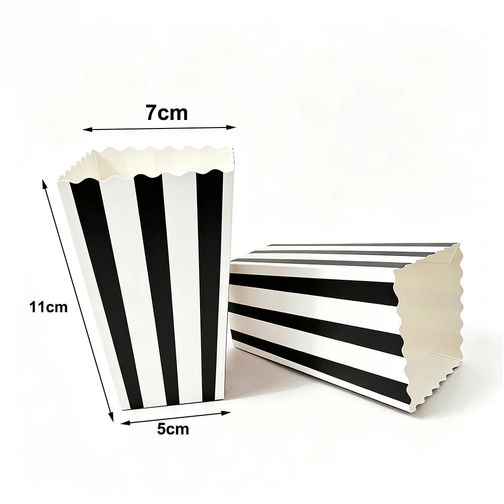 A white paper snack box with black diagonal stripes, shown next to a measurement guide.