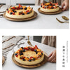 A slice of fruit tart decorated with berries and citrus served on a wooden tray.
