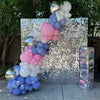 A sparkling backdrop made of iridescent sequins and balloons in shades of pink, purple, and white for a celebration.