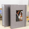 A gray linen photo album with a cover featuring a portrait of a smiling bride and groom.