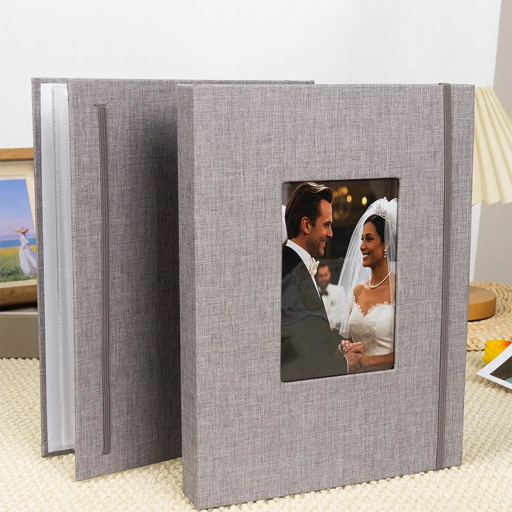 A gray linen photo album with a cover featuring a portrait of a smiling bride and groom.