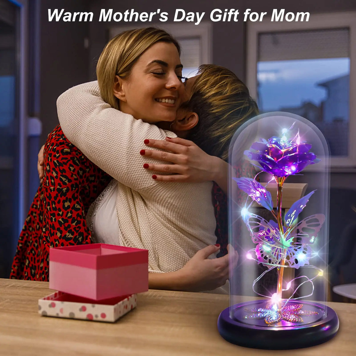 A rose crystal flower in an illuminated glass dome sits on a wooden table.