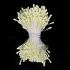 A bundle of small, pale yellow artificial flower stamens tied together with white string.