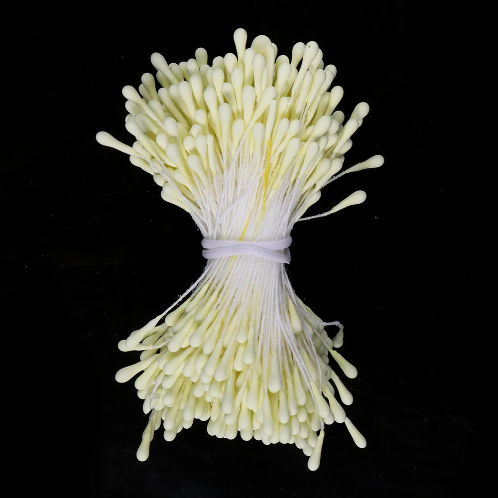 A bundle of small, pale yellow artificial flower stamens tied together with white string.