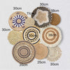 A collection of round boho straw wall hangings in various sizes and shades of natural beige and brown.