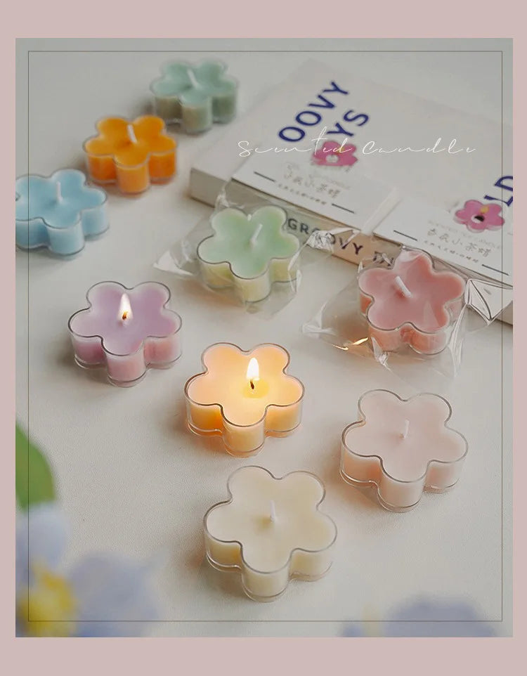 A collection of handmade soy wax flower tea light candles in various pastel colors arranged on a white surface.