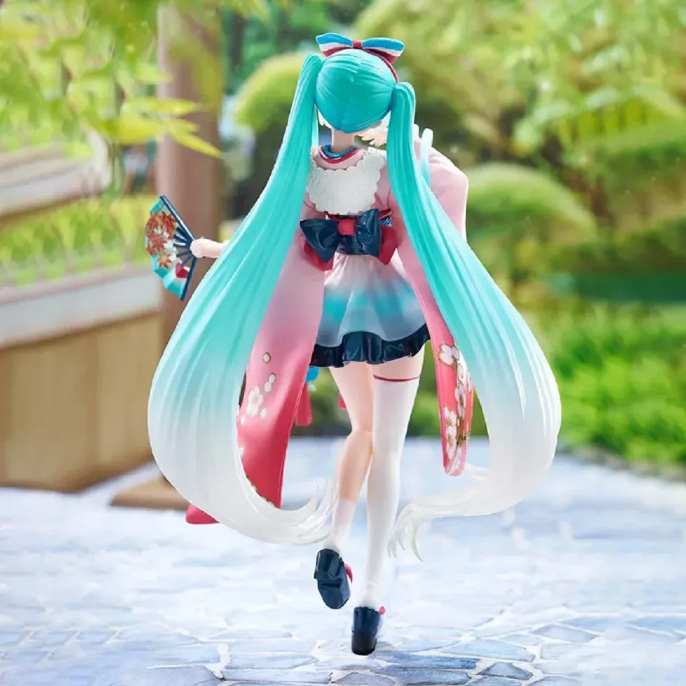 A PVC collectible figurine of Hatsune Miku in a pink and teal outfit with long flowing hair.