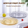 A set of clear acrylic fruit plates, including a round glass plate and a gold-rimmed plate, displayed on a white surface with