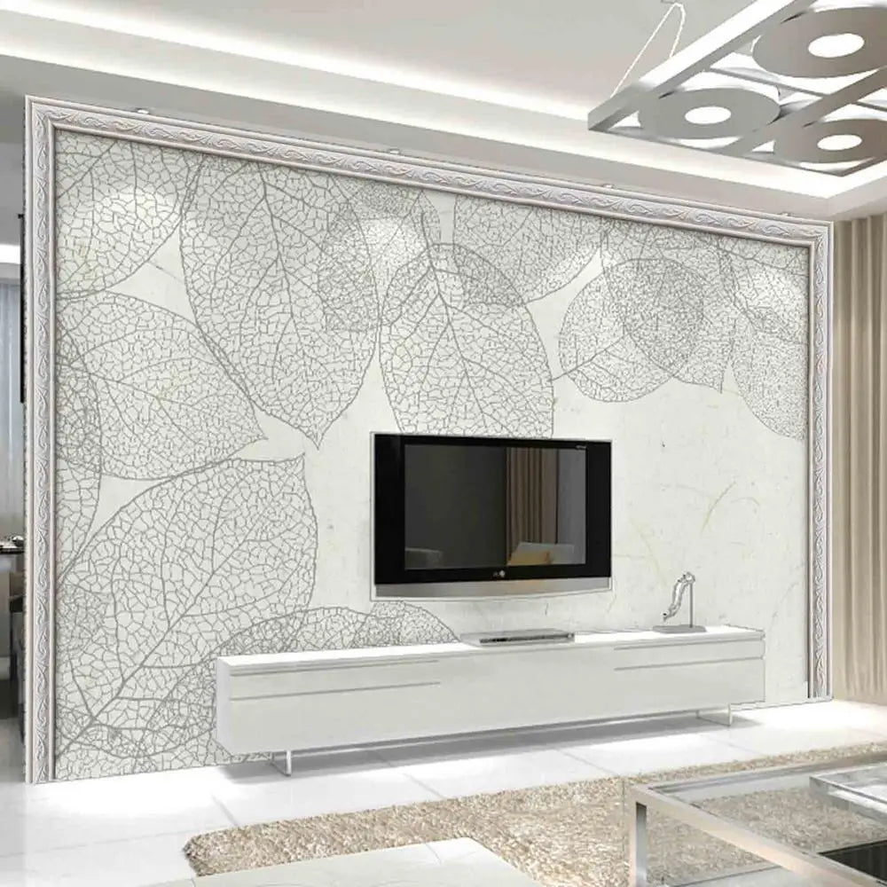 A modern interior featuring a large wall panel with a white leaf pattern and a mounted television.
