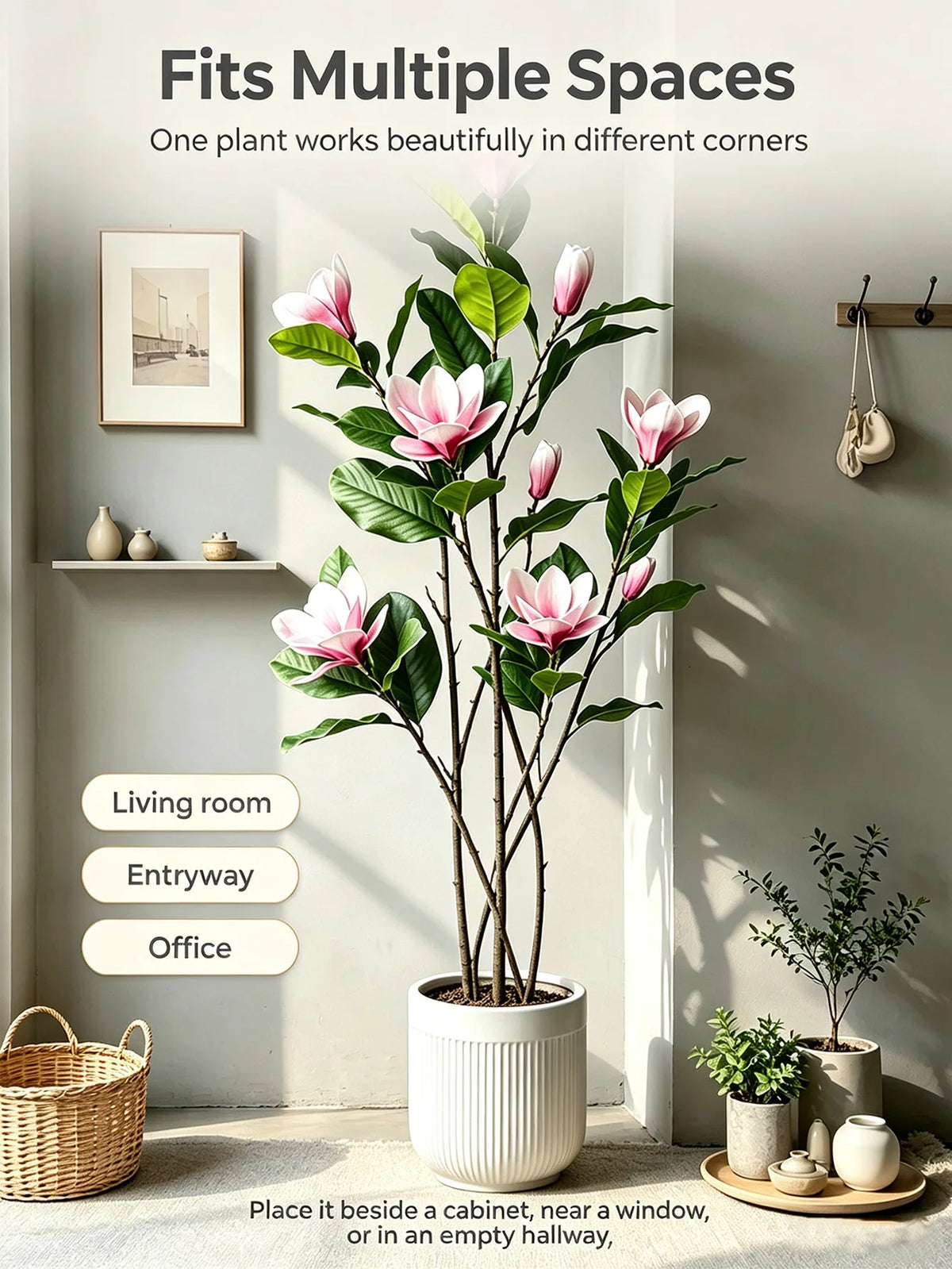 A tall artificial magnolia tree with pink and white silk flowers placed in a white pot indoors.