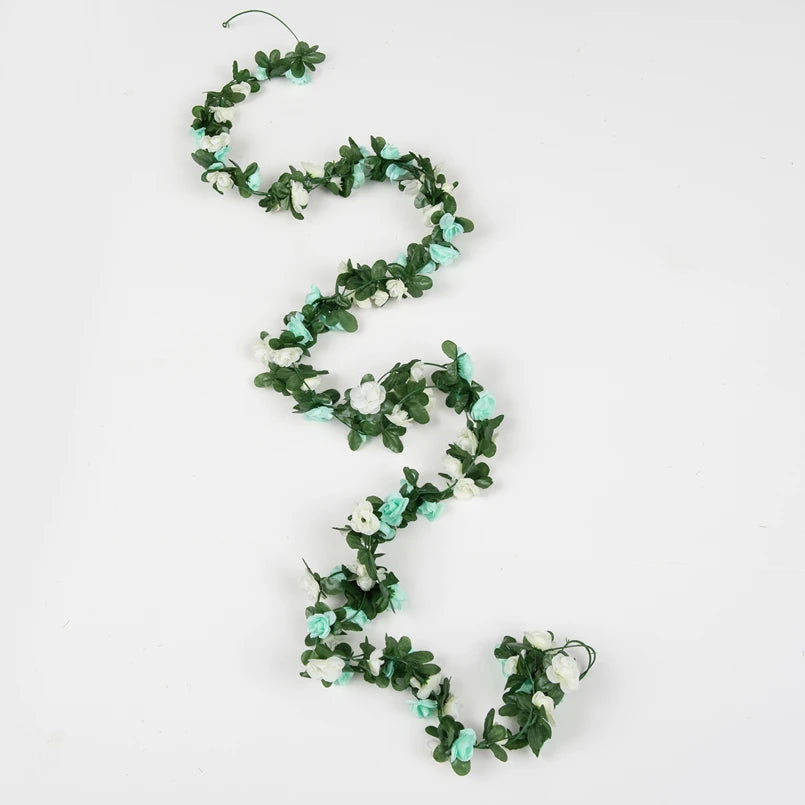 A delicate silk rose garland featuring light blue and white flowers, arranged in a winding vine pattern.