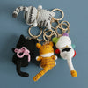 Handcrafted crochet cat keychain pendant featuring a white and gray striped cat figure.