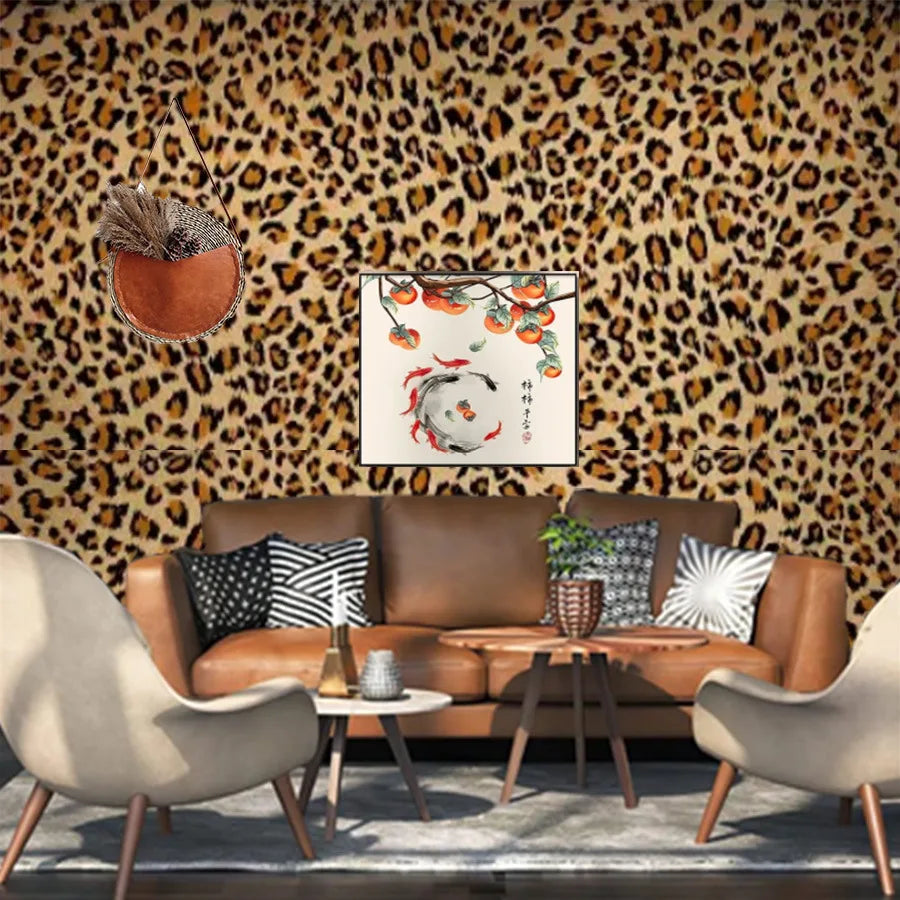 A living room featuring a brown leather sofa and armchairs against a leopard print wallpaper.
