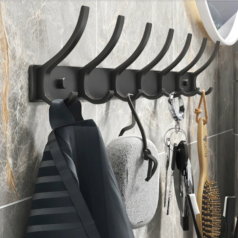 Un perchero de pared negro resistente con seis ganchos montados en una pared de azulejos grises.
