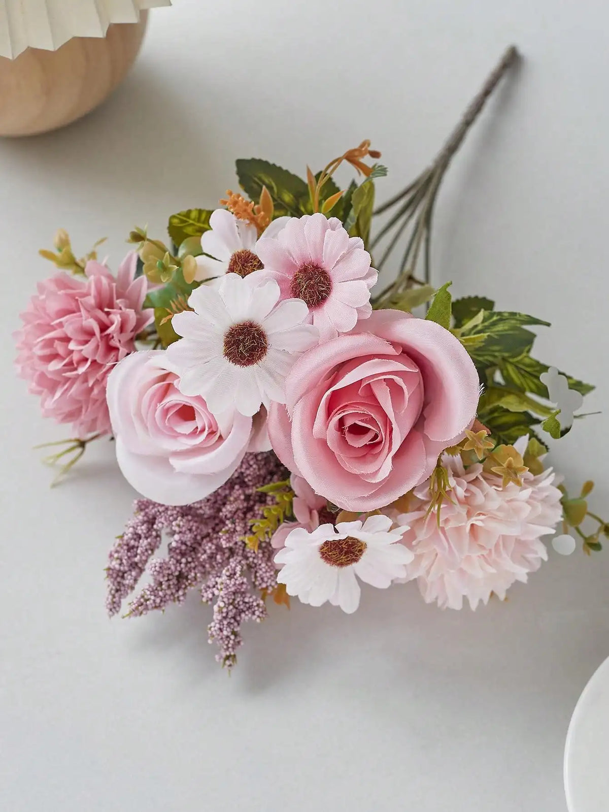 A bouquet of artificial silk flowers featuring pink and white roses, carnations, and lavender accents.