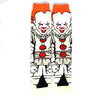 Pair of novelty crew socks featuring skull, alien, and tiger prints with orange trim