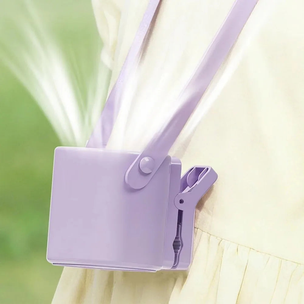 A purple clip-on mini electric fan is shown against a light green background.