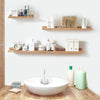 A white ceramic vessel sits on a wooden surface in front of a display of skincare products and various bottles.