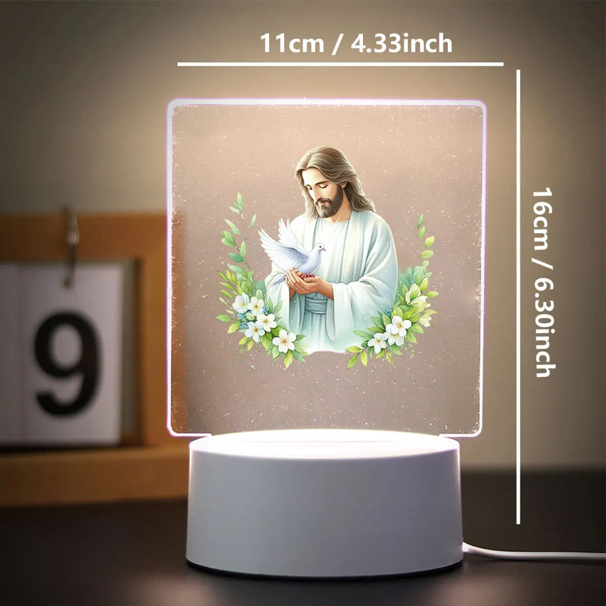 A square 3D LED night light featuring a depiction of Jesus with a wreath of flowers on a light background.