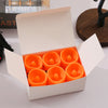 A cardboard box containing six orange battery-powered LED Halloween candles with flickering flames.