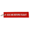 Red woven keychain with white text that reads Kiss Me Before Flight