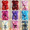 Eine Sammlung von künstlichen Rosen-Teddybären in verschiedenen Farben, darunter rot, rosa, lila, blau und weiß.