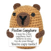 A handmade crochet capybara figurine with an inspirational card that says I may be a tiny capybara but I believe in you go do