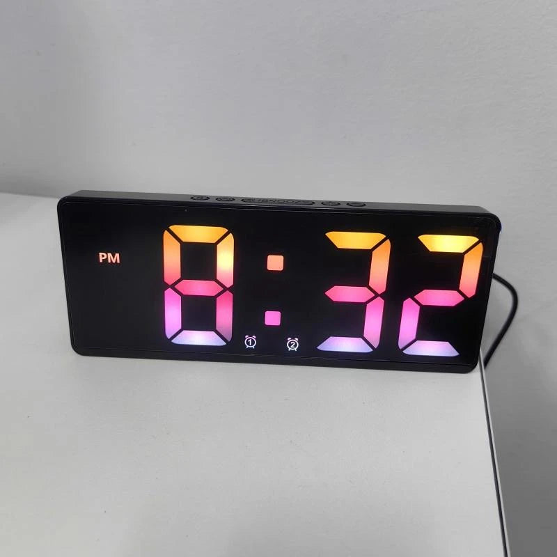 A black digital alarm clock displaying 8:32 in bright orange and pink LED numbers.