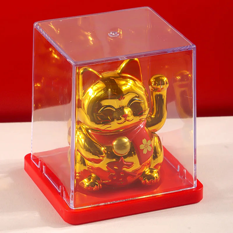 A solar-powered waving lucky cat figurine housed in a clear box on a red base.