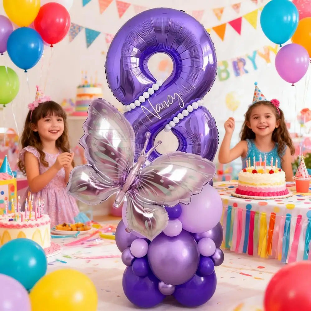 Globos con forma de mariposa morada y números decorando una fiesta de cumpleaños infantil