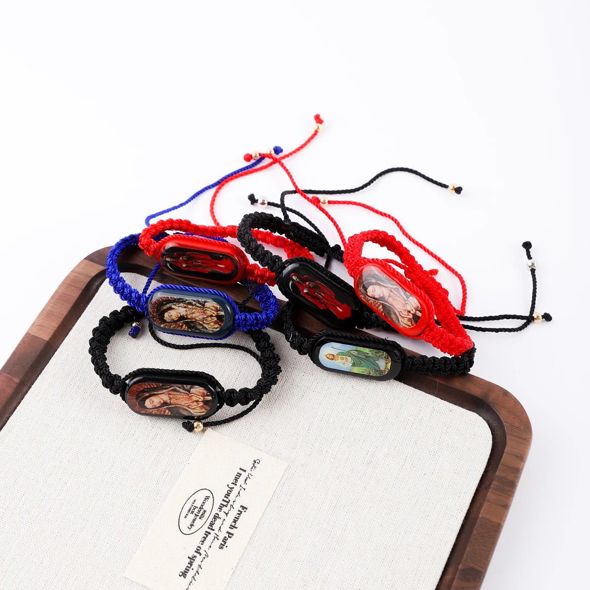 A collection of vintage wooden Virgin Mary prayer bracelets in various colors including red blue and black