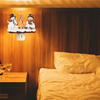 A night light decoration featuring snowmen and a flickering campfire on a wooden panel.