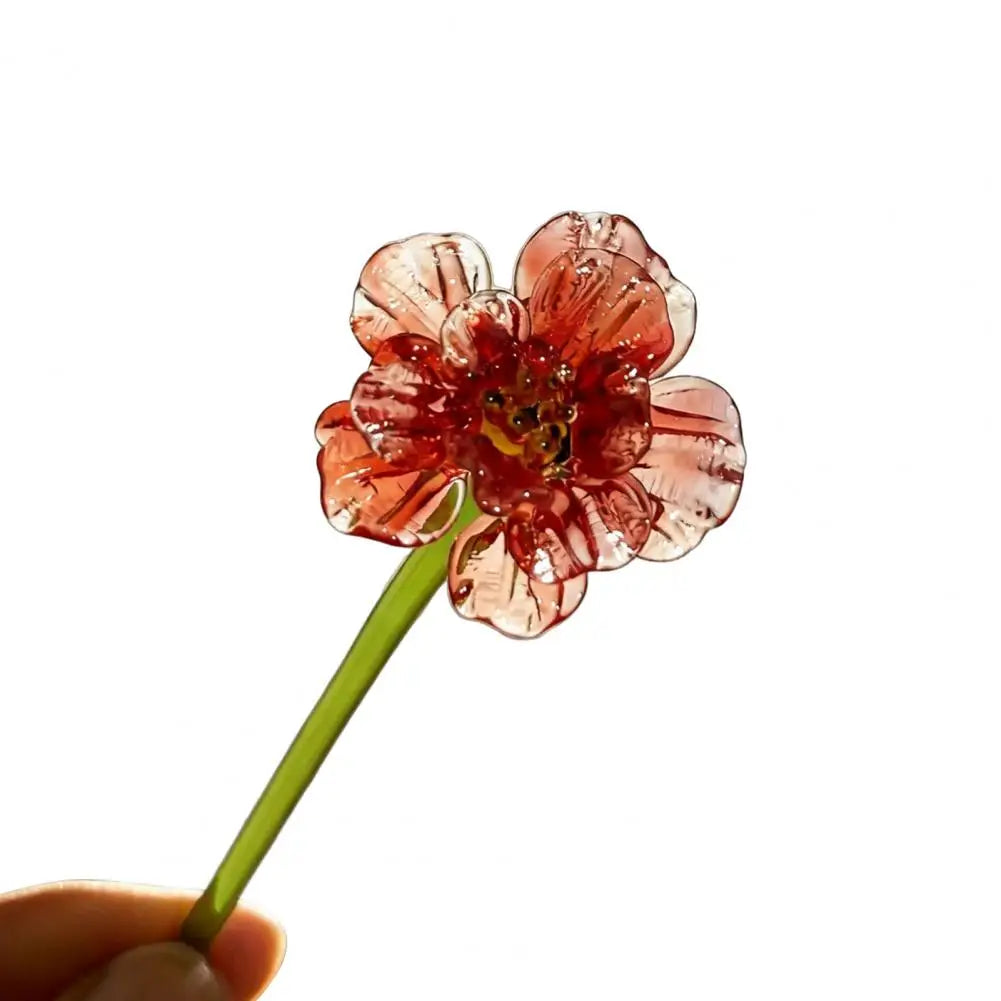 Handcrafted blue glass flower sculpture with reddish-pink petals and green stem