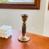 A vintage resin wall sconce candle holder with a fluted top and base, displayed on a wooden surface.