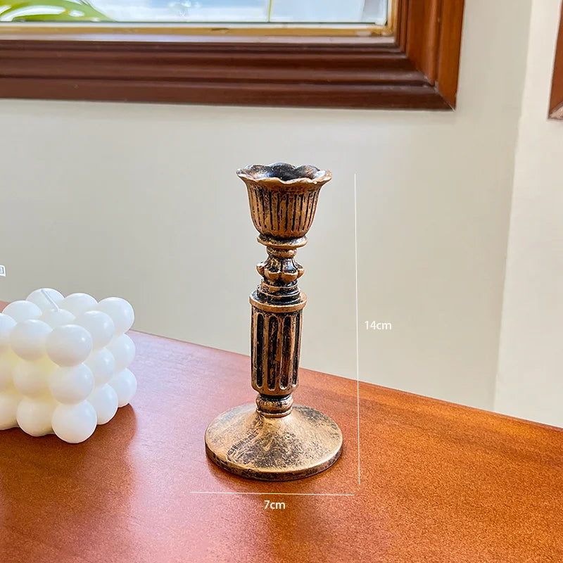 A vintage resin wall sconce candle holder with a fluted top and base, displayed on a wooden surface.