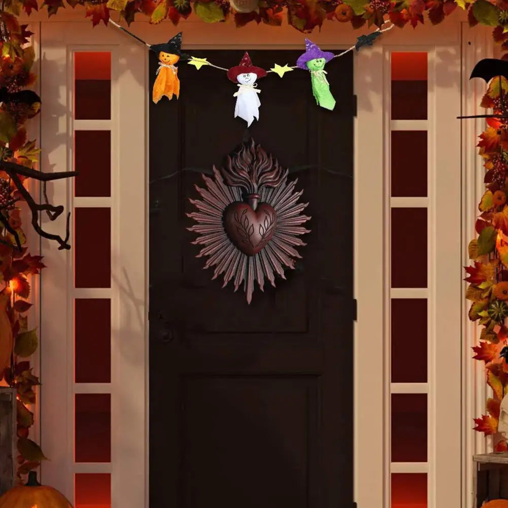 A dark wooden door decorated with Halloween-themed hanging ornaments and a large, ornate heart plaque.