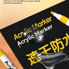A close-up of a black acrylic marker set on a dark surface with yellow text and an open packaging view.